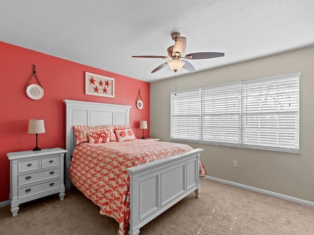 bedroom featuring carpet floors, baseboards, a textured ceiling, and a ceiling fan