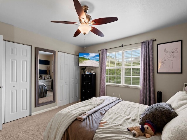 carpeted bedroom with multiple closets and ceiling fan