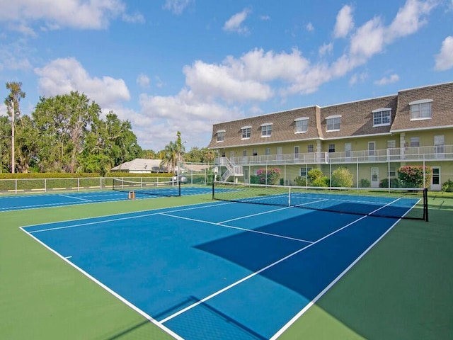 view of tennis court with fence and community basketball court