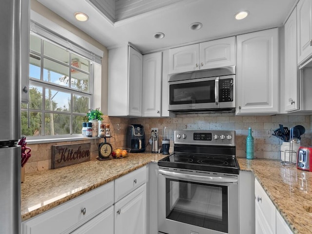 kitchen with appliances with stainless steel finishes, white cabinetry, decorative backsplash, light stone countertops, and recessed lighting