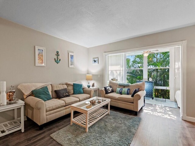 living area featuring wood finished floors, a textured ceiling, and baseboards