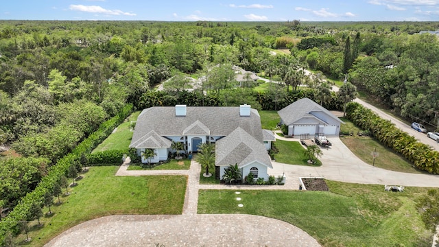 aerial view of property and surrounding area featuring a forest
