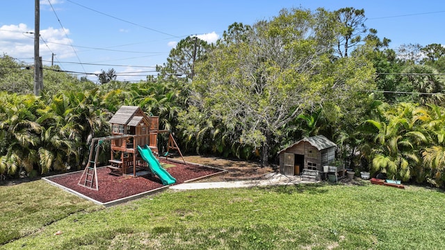 view of playground featuring a lawn, a shed, and an outbuilding