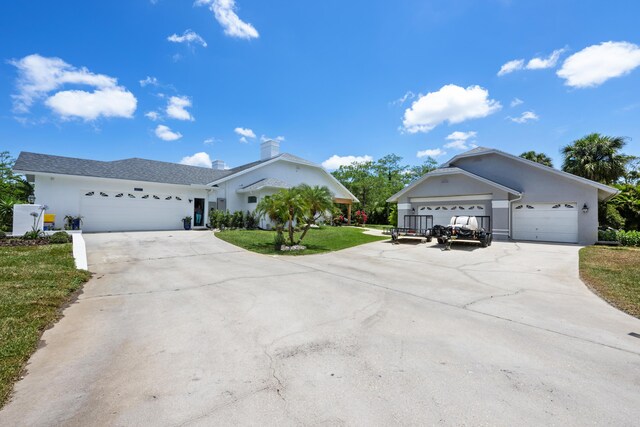 ranch-style home with concrete driveway, a front yard, stucco siding, and a garage