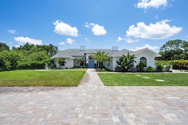view of front facade with a front lawn and stucco siding