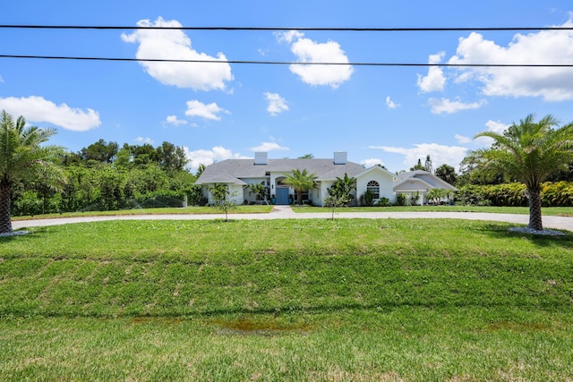ranch-style house featuring a front lawn and curved driveway