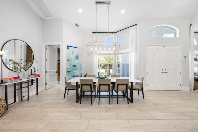 dining space featuring a chandelier and a high ceiling