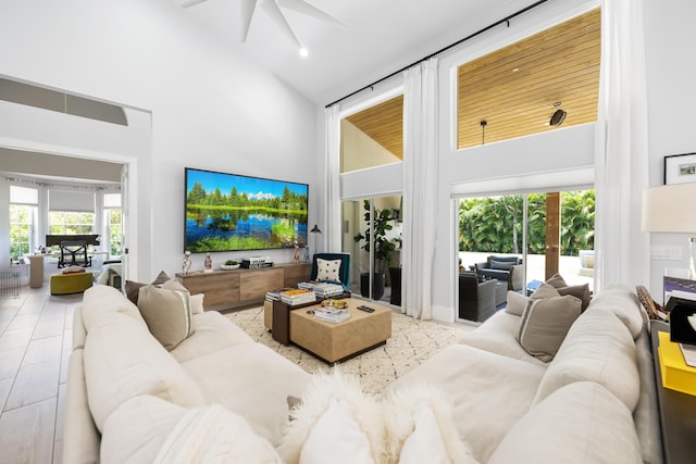 tiled living area with high vaulted ceiling and a ceiling fan