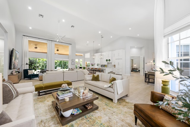 living area with high vaulted ceiling and recessed lighting