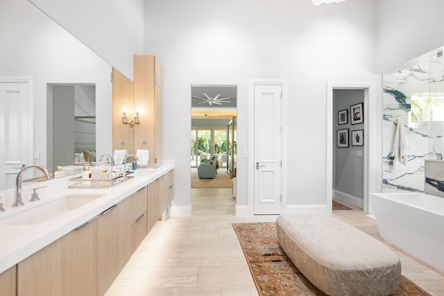 full bathroom with a tub, double vanity, and a towering ceiling