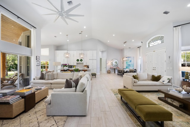 living room with high vaulted ceiling, ceiling fan, light wood-type flooring, and recessed lighting