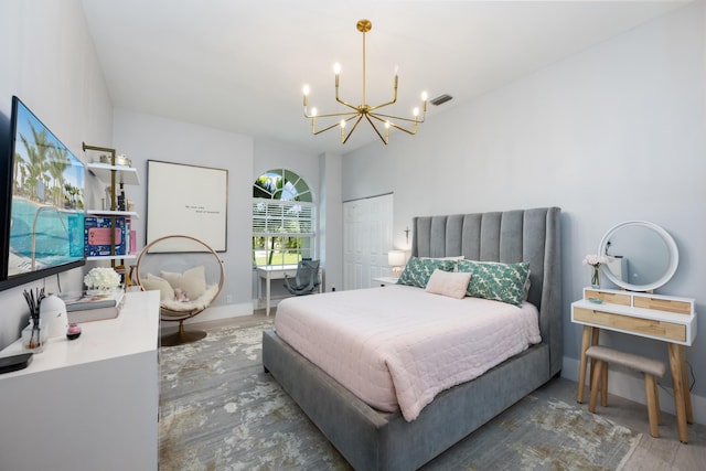bedroom featuring a chandelier, wood finished floors, and baseboards