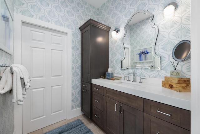 bathroom with wallpapered walls and vanity