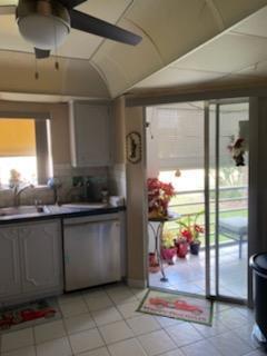 3755 Via Poinciana Unit 203, Lake Worth, FL 33467 - kitchen with stainless steel dishwasher, a sink, and light tile patterned floors