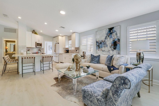 5021 Magnolia Bay Cir, Palm Beach Gardens, FL 33418 - living room featuring light wood-type flooring, vaulted ceiling, recessed lighting, and baseboards