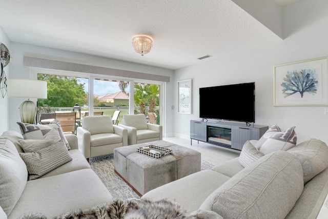 5021 Magnolia Bay Cir, Palm Beach Gardens, FL 33418 - living room with plenty of natural light, a textured ceiling, and baseboards