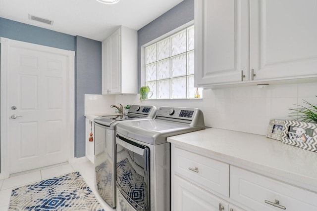 5021 Magnolia Bay Cir, Palm Beach Gardens, FL 33418 - laundry area featuring cabinet space, washer and clothes dryer, and light tile patterned flooring