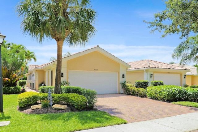 5021 Magnolia Bay Cir, Palm Beach Gardens, FL 33418 - view of front of house with a tile roof, a garage, stucco siding, and decorative driveway