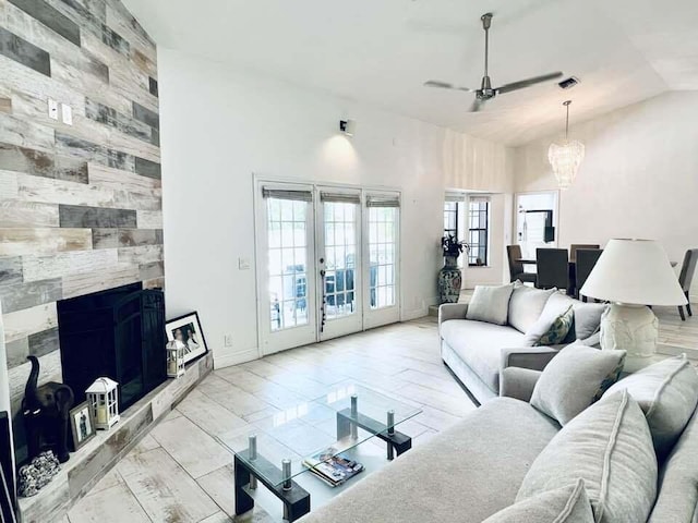 1855 Primrose Ln, Wellington, FL 33414 - living room featuring ceiling fan, a chandelier, a fireplace, high vaulted ceiling, and french doors