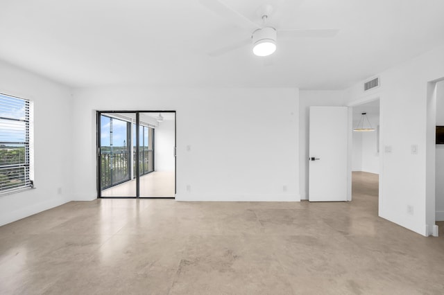 spare room with baseboards, concrete floors, and a ceiling fan