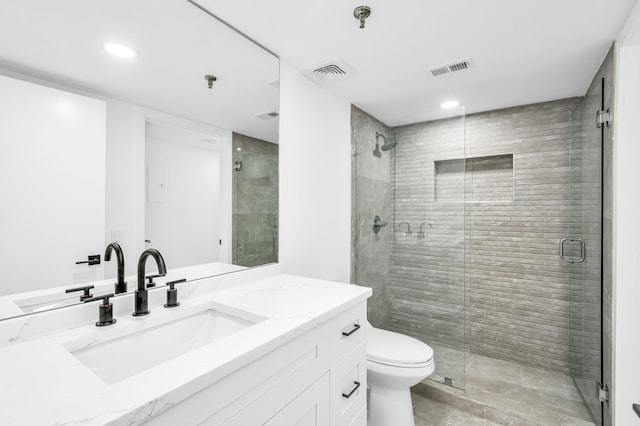 bathroom with a stall shower, vanity, toilet, and recessed lighting