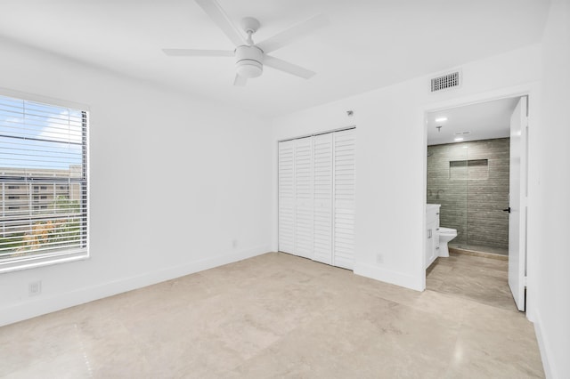 unfurnished bedroom with a closet, ensuite bathroom, baseboards, and ceiling fan