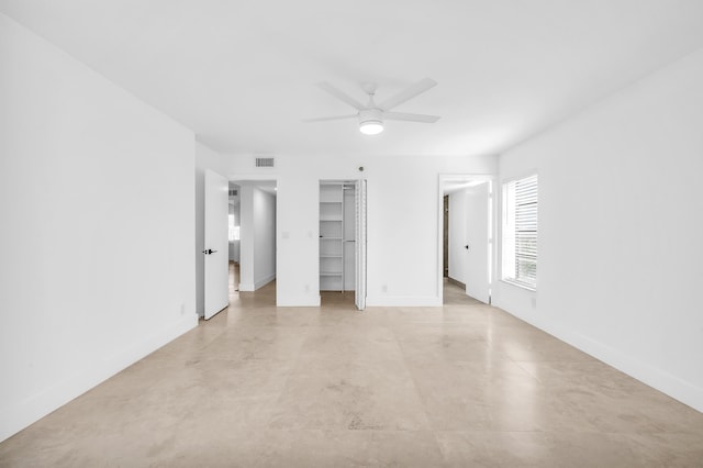 unfurnished bedroom with baseboards, ceiling fan, and a spacious closet