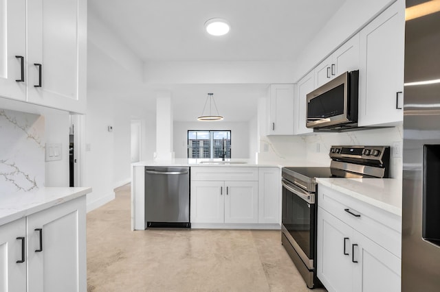 kitchen featuring stainless steel appliances, white cabinets, a peninsula, hanging light fixtures, and finished concrete flooring