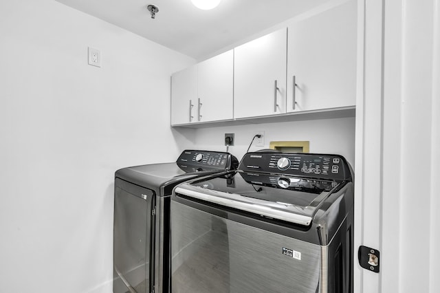 washroom with cabinet space and separate washer and dryer