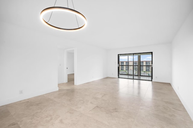 unfurnished living room with concrete flooring and baseboards