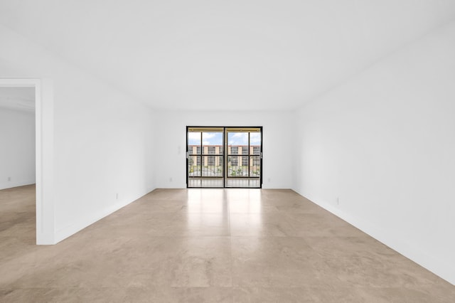 unfurnished room with finished concrete floors and baseboards