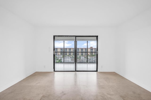 unfurnished room with concrete floors and baseboards
