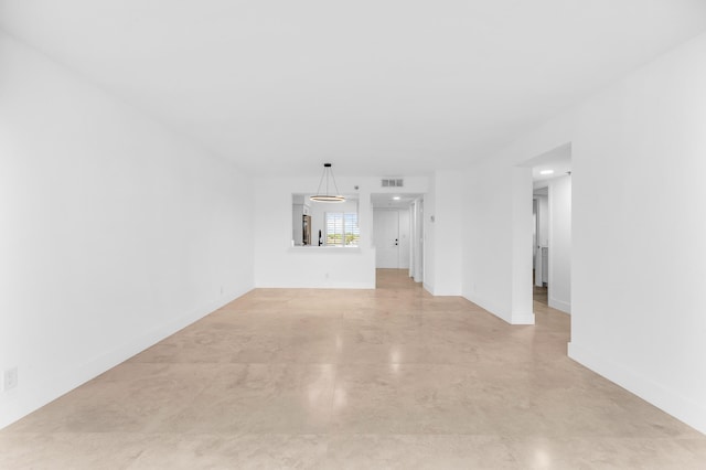 unfurnished living room with finished concrete flooring and baseboards