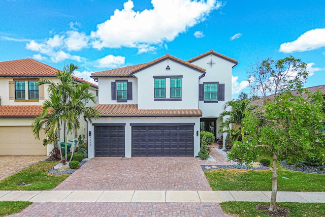 8640 E Baypoint Cir, Parkland, FL 33076 - mediterranean / spanish-style home featuring a tile roof, an attached garage, stucco siding, and decorative driveway
