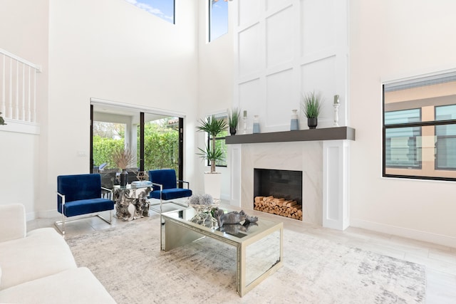 8640 E Baypoint Cir, Parkland, FL 33076 - living area featuring a towering ceiling, a premium fireplace, and baseboards