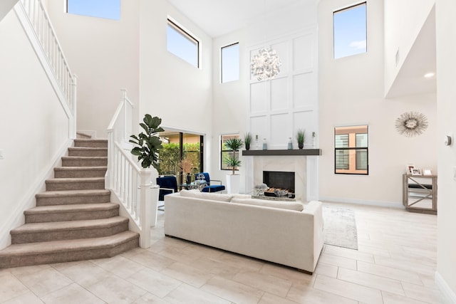 8640 E Baypoint Cir, Parkland, FL 33076 - living area featuring a high ceiling, stairs, plenty of natural light, a high end fireplace, and baseboards