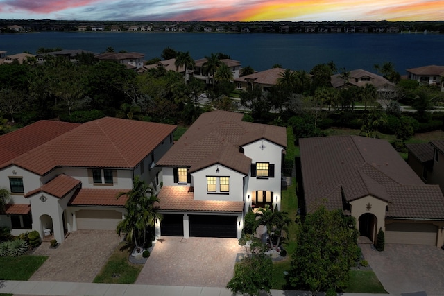 8640 E Baypoint Cir, Parkland, FL 33076 - view of front of home with a tiled roof, a garage, driveway, stucco siding, and a water view