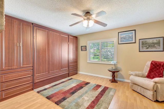 1420 NW 27th Ave, Delray Beach, FL 33445 - living area featuring light wood-type flooring, ceiling fan, a textured ceiling, and baseboards