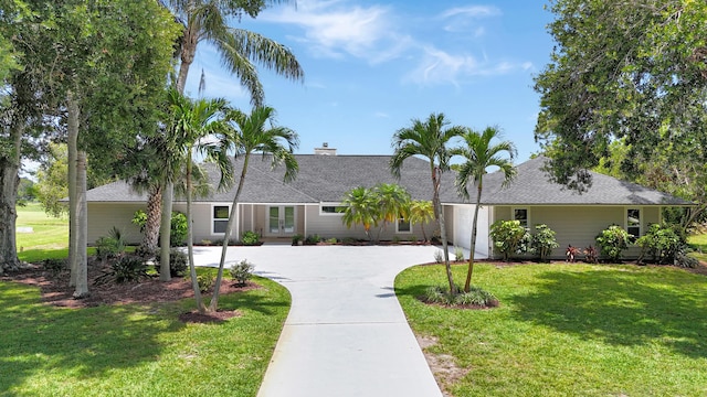 single story home with french doors, driveway, a front lawn, roof with shingles, and a garage