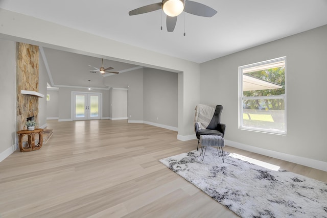 sitting room with french doors, a ceiling fan, light wood-type flooring, and baseboards