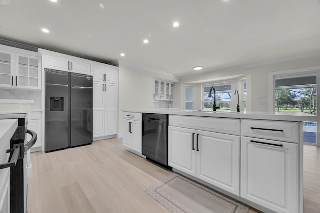 kitchen featuring stainless steel refrigerator with ice dispenser, dishwasher, a sink, ornamental molding, and glass insert cabinets