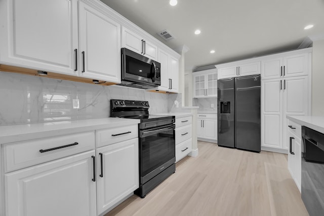 kitchen with appliances with stainless steel finishes, white cabinets, recessed lighting, light countertops, and decorative backsplash