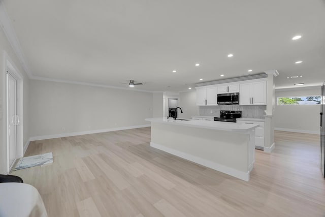 kitchen with stainless steel appliances, ornamental molding, recessed lighting, light countertops, and baseboards