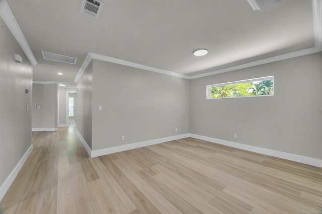 spare room featuring crown molding, light wood-style floors, baseboards, attic access, and recessed lighting