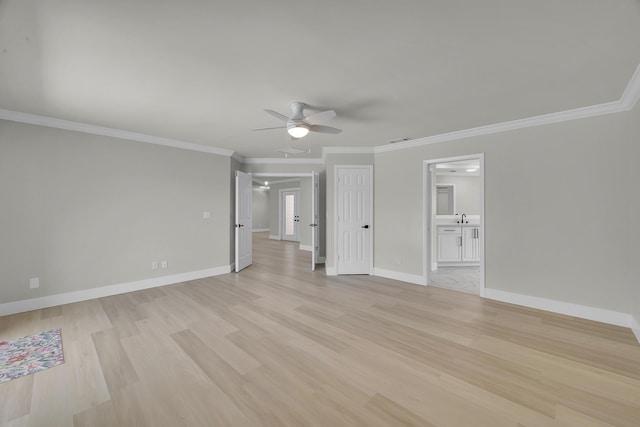 spare room featuring ceiling fan, light wood-type flooring, ornamental molding, baseboards, and a sink