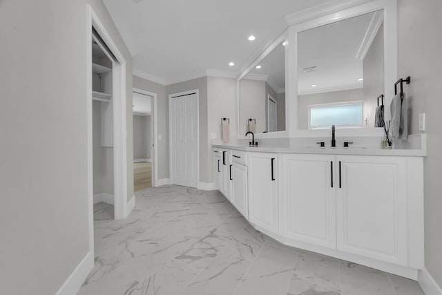 full bathroom featuring marble finish floors, baseboards, crown molding, double vanity, and a closet