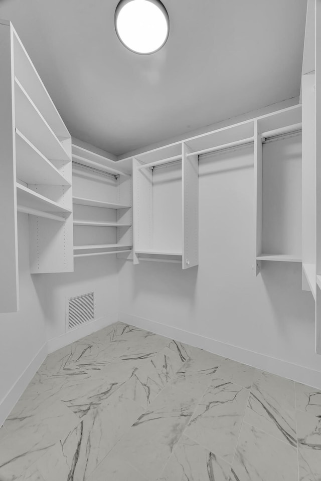 walk in closet with marble finish flooring