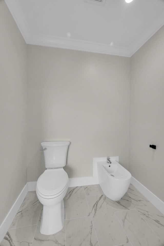 bathroom with baseboards, ornamental molding, marble finish floors, toilet, and a bidet