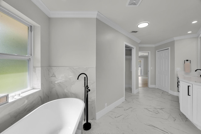full bathroom with a freestanding tub, vanity, marble look tile flooring, ornamental molding, and recessed lighting