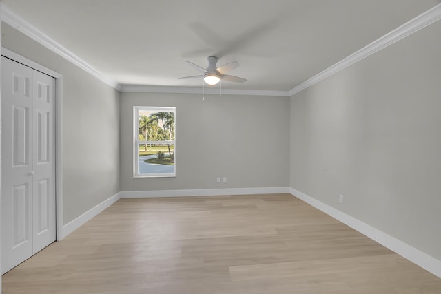 unfurnished bedroom with ornamental molding, baseboards, light wood finished floors, and a closet